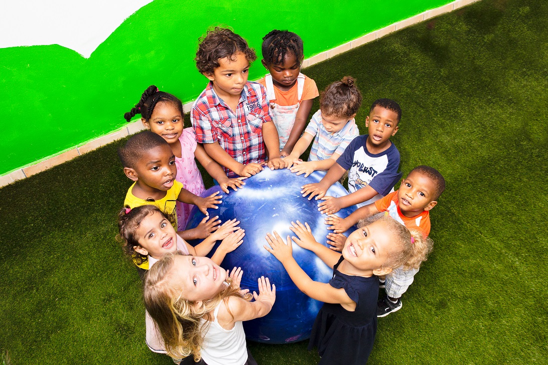 children holding their hands on blue ball